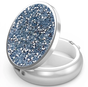 Detail of round metal pill box with blue and white rhinestones and two-compartment interior