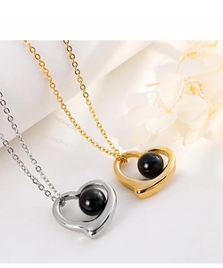 Detailed macro view of heart-shaped pendants with black beads in gold and silver finish