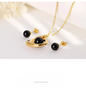 Detail view of a vintage heart necklace with black beads and matching stud earrings