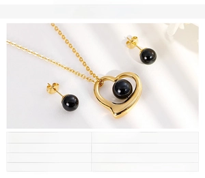 Detailed view of gold heart necklace and black bead earrings set with size parameters