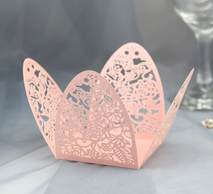 Detailed laser-cut hollow rose pattern on pink paper favor box for wedding decor