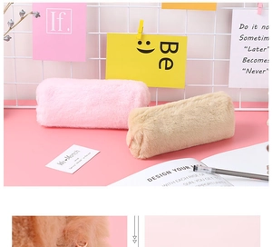 Nahaufnahme von weichen Plüsch-Federmäppchen in Rosa und Beige auf einem Schreibtisch