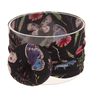 Detalle de diadema para bebé de nailon con estampado bohemio y gran nudo suave.