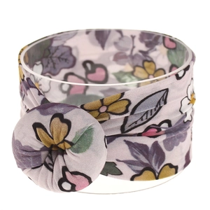Detalle de diadema de nailon floral con textura de tela suave y botón redondo decorativo
