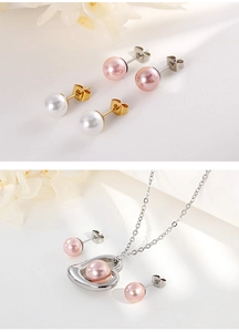 Detail view of heart pendant necklace and pearl earrings in pink and white finishes