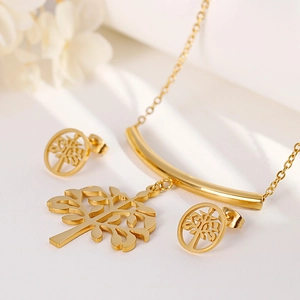 Elegant gold tree of life necklace and earrings jewelry set for women on white floral backdrop