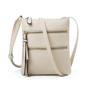 Minimalist beige crossbody bag for women featuring three zippers and a tassel detail