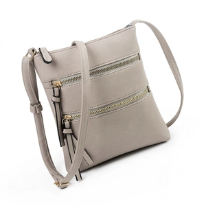 Detailed side view of grey multi-zipper crossbody bag showing layered structure