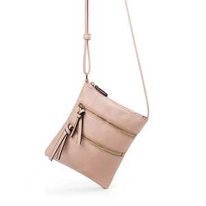 Detail view of pink multi-zipper crossbody bag with leather texture and tassel accent
