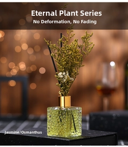 Close-up of reed diffuser set with embossed glass bottle and yellow dried flowers