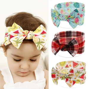 Detail of floral and fruit print nylon baby headbands featuring large handmade bows
