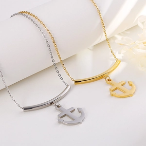 Gold and silver anchor necklaces on delicate cable chains with curved bar accents