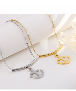 Close-up of anchor pendant necklaces in gold and silver finish on display props