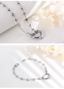 Close-up of silver heart-shaped necklace and bracelet set with delicate link chains