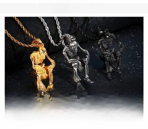 Macro view of toilet skull pendants in gold, silver, and black stainless steel