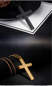 Close-up of black and gold stainless steel cross pendants with knurled texture details