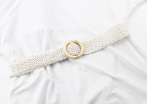 Gros plan sur une ceinture tressée blanche avec boucle ronde en bois naturel