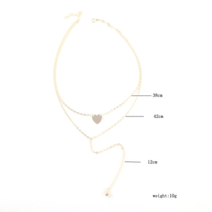 Détail du collier multicouche doré avec pendentif cœur et mesures de longueur de 38cm et 42cm