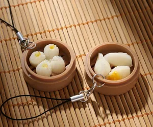 Macro detail of realistic artificial dumplings and shumai pendants in mini steam baskets