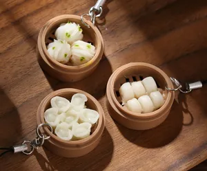 Realistic mini dim sum keychain with bamboo steamer detail on dark wood background