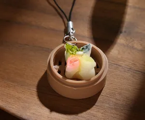 Macro shot of colorful steamed bun keychain in mini bamboo steamer on wood table