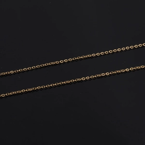 Dettaglio di due catenine a maglia in acciaio inossidabile placcato oro 18k su sfondo nero