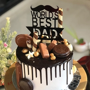 Detail of World's Best Dad acrylic cake topper with chocolate drips and golden stars