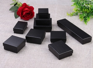 Detail view of assorted black jewelry gift boxes with elegant diamond texture pattern