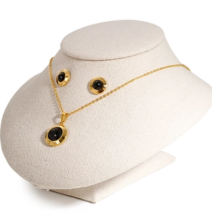 Elegant gold jewelry set featuring a round black crystal necklace and matching earrings