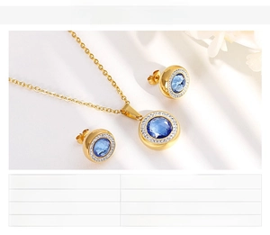 Detail of gold-plated necklace and earrings set featuring blue round glass crystals
