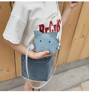 Detail of blue cartoon pig crossbody bag for kids featuring PU leather and zipper