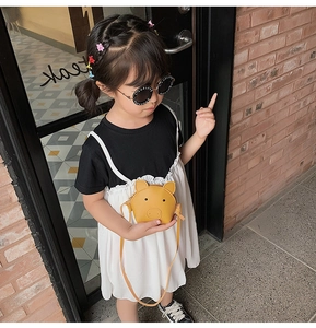 Cute yellow pig cartoon shoulder bag for kids shown on model in street style setting