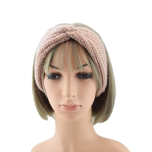 Close-up of knit twisted headband in soft pink on a mannequin head for winter warmth
