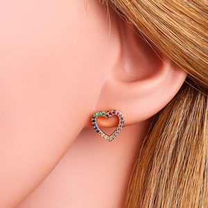 Elegant gold heart stud earrings with rainbow cubic zirconia on a female model