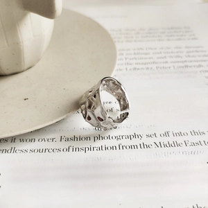 Detail view of irregular hammered silver 925 ring on minimalist magazine background
