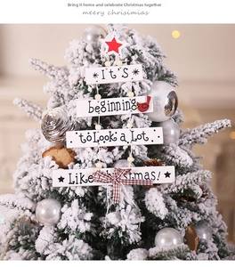 Close-up of wooden Christmas tree hanging sign with red stars and plaid bow decoration