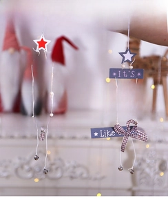Detail of wooden Christmas tree hanging ornaments with stars, bells and festive greetings