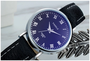 Detail view of quartz watch with blue dial, roman numerals and black leather strap