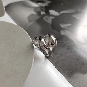 Detailed view of polished silver 925 irregular ring on a minimalist pedestal