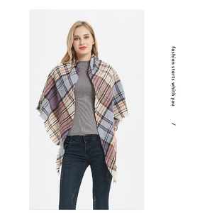 Close-up of a soft plaid tassel shawl in blue, purple, and beige tones worn by a model
