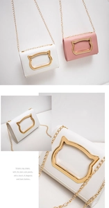 Detail of elegant cat-shaped golden metal clasp and chain on PU crossbody bag
