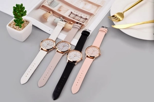 Flat lay of four leather quartz watches in white beige black and pink with rose gold cases