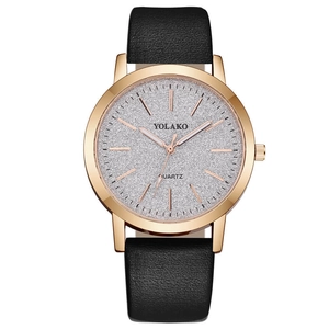 Macro shot of rose gold watch case featuring silver glitter dial and black leather strap