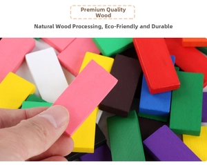 Close-up of hand holding a pink block from a colorful natural wood domino set