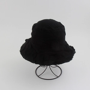Detail of frayed edge trim and black cotton canvas fabric on casual bucket hat