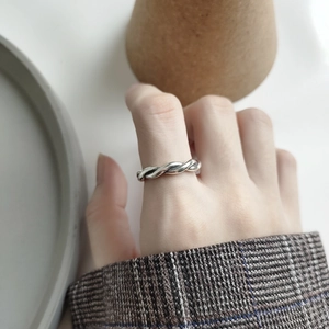 Close-up of a vintage 925 sterling silver woven rope ring worn on a model finger