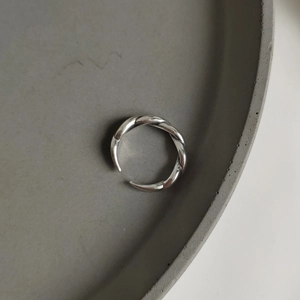 Detail of a vintage 925 sterling silver twisted rope ring on a minimalist stone tray