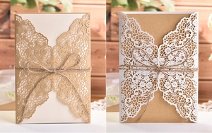 Detail of laser-cut butterfly invitation with kraft paper, white lace and hemp rope