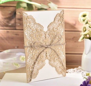 Detail of laser-cut butterfly wedding invitation with rustic twine and wood backdrop