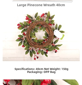 Détail d'une couronne de Noël de 40cm avec baies rouges et feuilles sur base de vigne